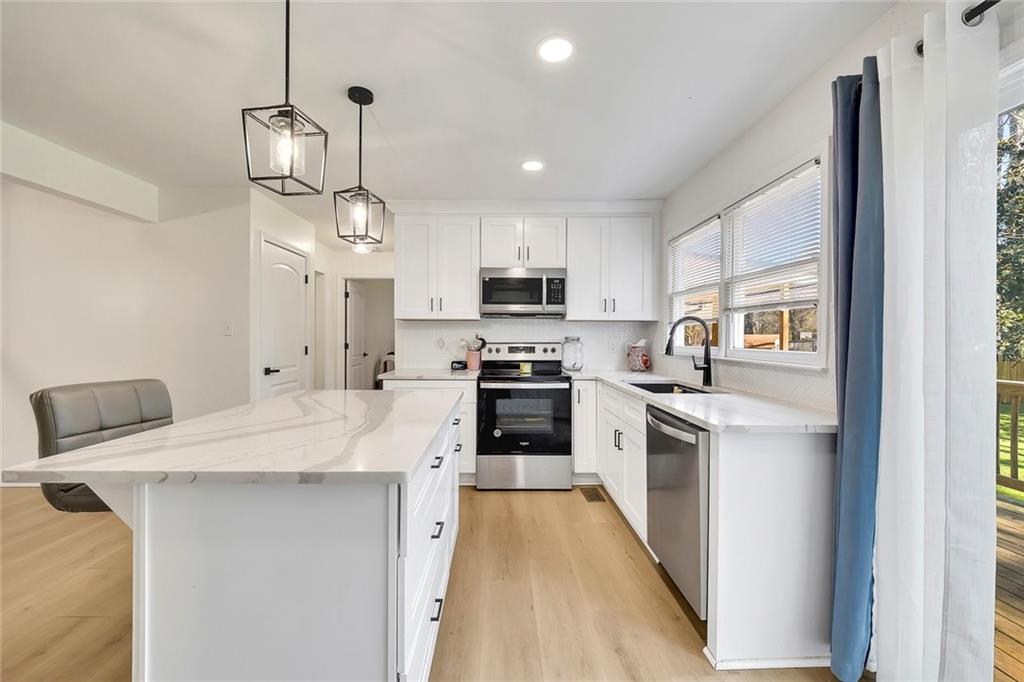 2328 Carnes Road Jonesboro, GA 30236 - Photo 12 of 36 a kitchen with a sink a counter top space stainless steel appliances and cabinets