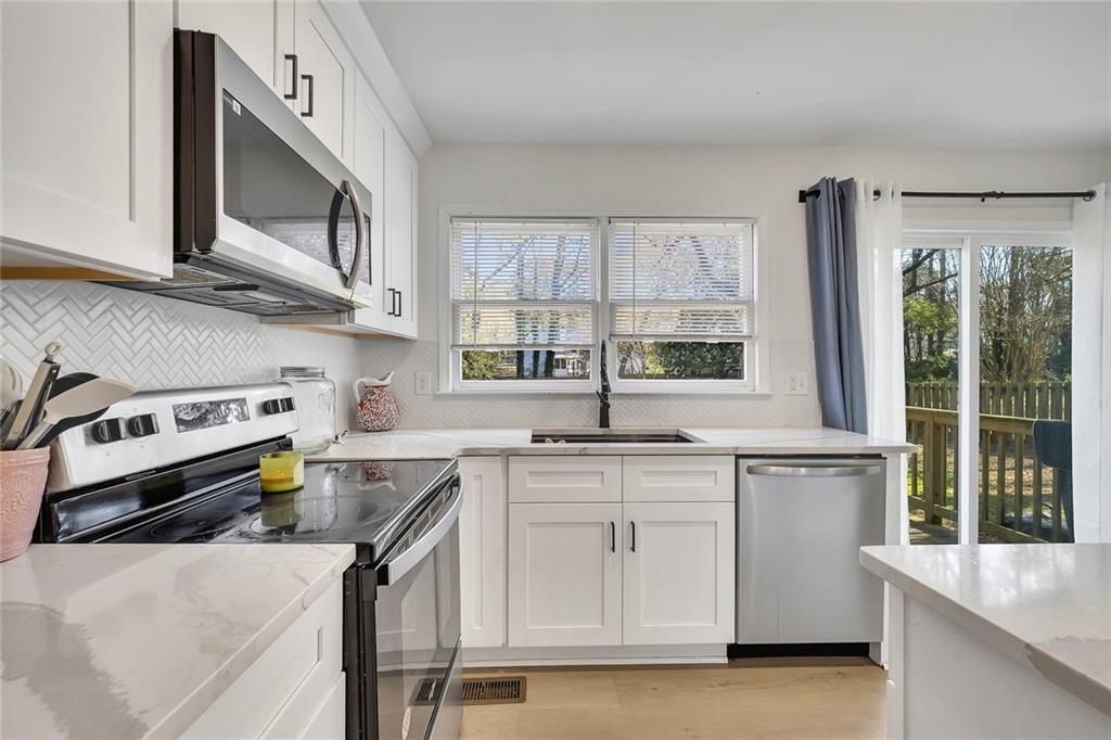 2328 Carnes Road Jonesboro, GA 30236 - Photo 14 of 36 a kitchen with stainless steel appliances granite countertop a stove a sink and a microwave