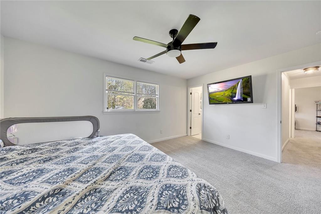 2328 Carnes Road Jonesboro, GA 30236 - Photo 21 of 36 a bedroom with a large bed and a chandelier