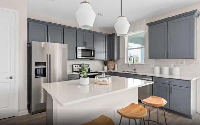 a kitchen with a sink a kitchen island and chairs