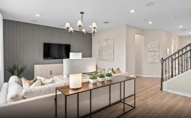 a living room with furniture a chandelier and a flat screen tv