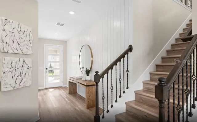 a view of staircase with lots of frames on wall and a window