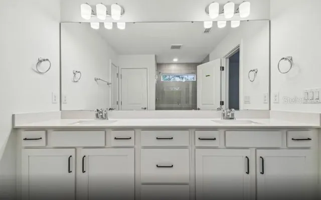 a bathroom with a sink double vanity and a mirror