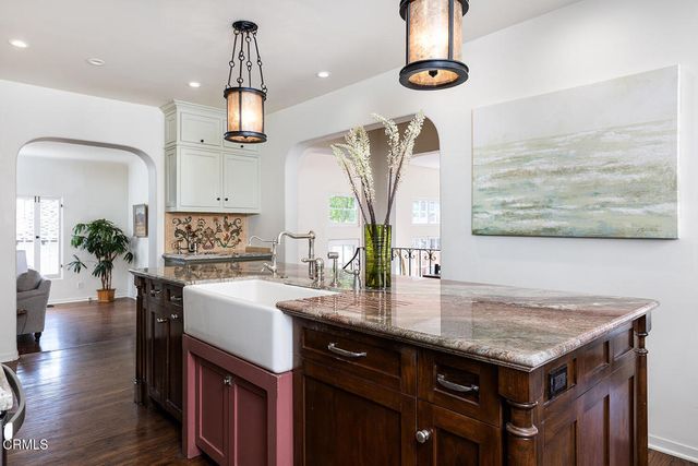 a kitchen with kitchen island granite countertop a sink appliances and cabinets