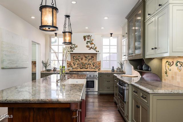 a kitchen with a stove and a wooden floor