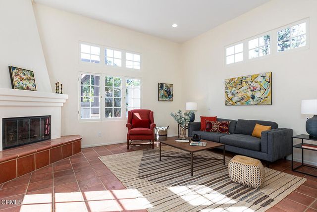 a living room with furniture a fireplace and a floor to ceiling window