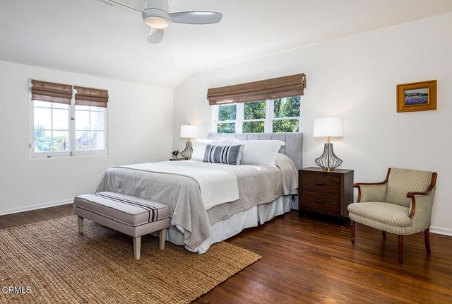 a bedroom with a large bed and wooden floor