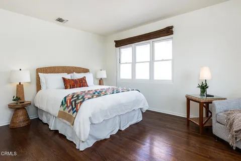 a bedroom with a bed and a chair with the potted plant