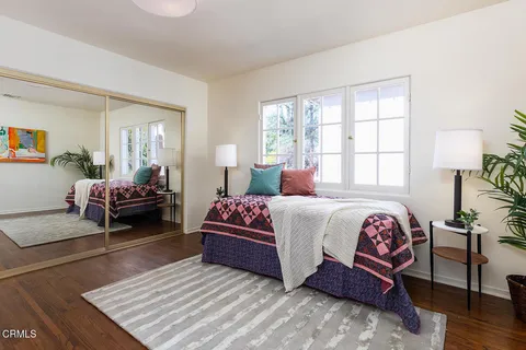 a bedroom with a bed and wooden floor