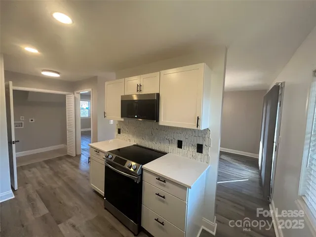 a kitchen with granite countertop a sink and a stove top oven