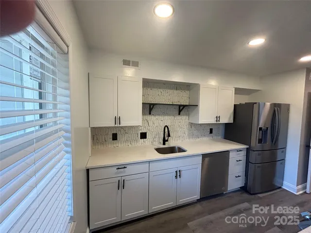 a kitchen with white cabinets and stainless steel appliances