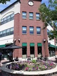 a view of brick building with many windows and yard