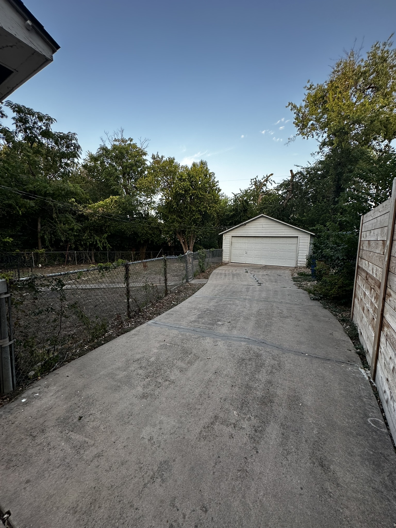 3903 Ridgelea Drive Austin, TX 78731 - Photo 16 of 17 A long concrete driveway leads to a detached garage flanked by secure fencing.
