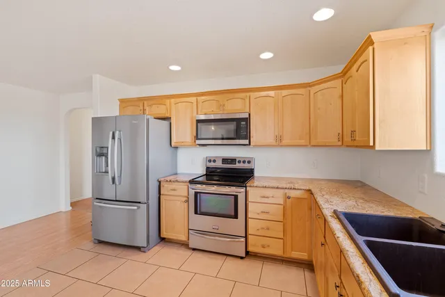 a large white kitchen with a sink and cabinets