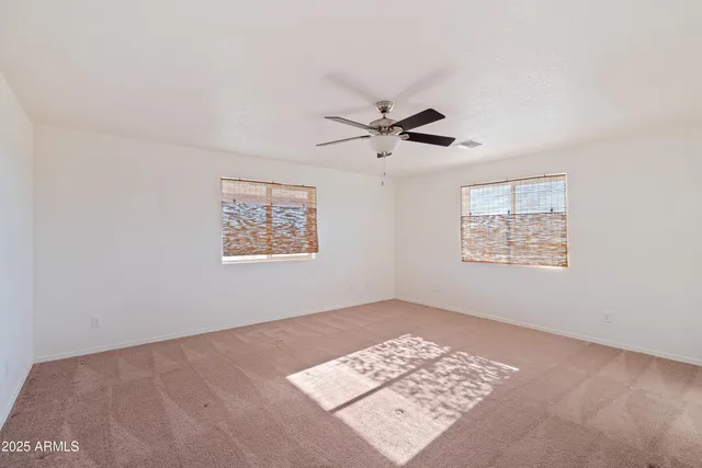 an empty room with a view of a ceiling fan