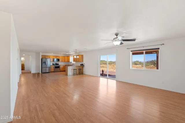 a view of a livingroom with furniture a ceiling fan and wooden floor
