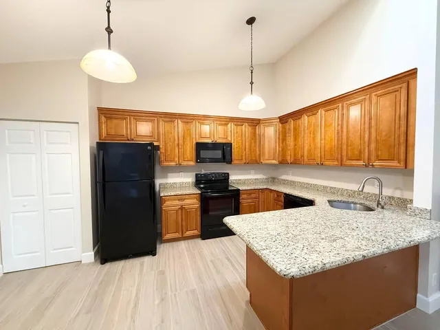 a kitchen with granite countertop kitchen island stainless steel appliances a refrigerator sink and microwave