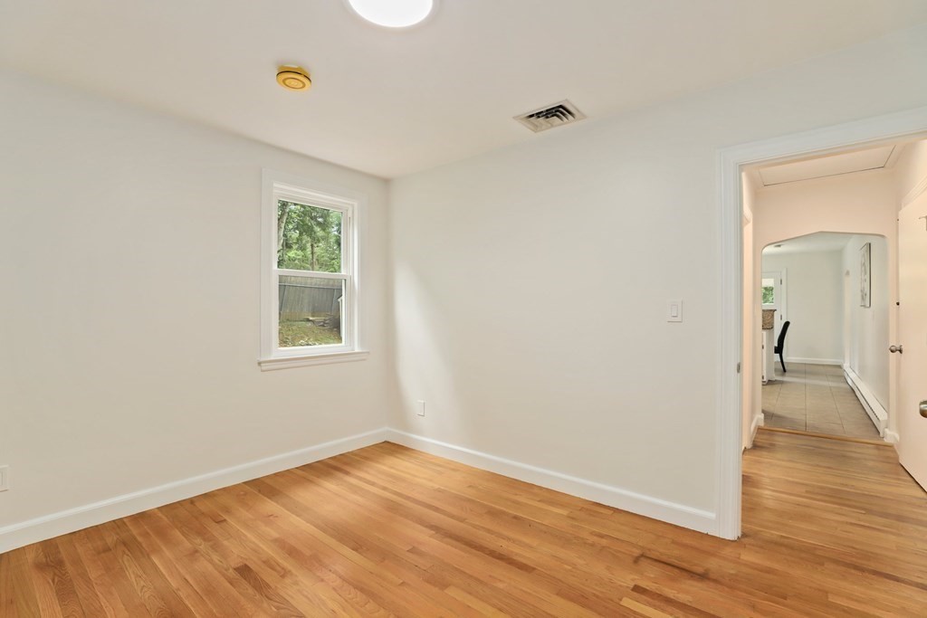 1177 Bay Road Sharon, MA 02067 - Photo 18 of 27 a view of an empty room with wooden floor and a window