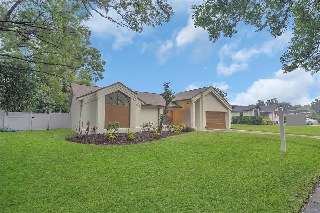 a front view of a house with a yard and trees