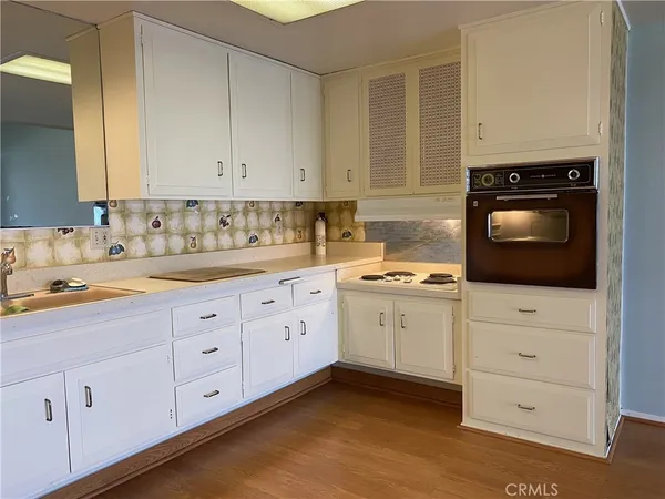 a kitchen with cabinets stainless steel appliances a sink and wooden floor