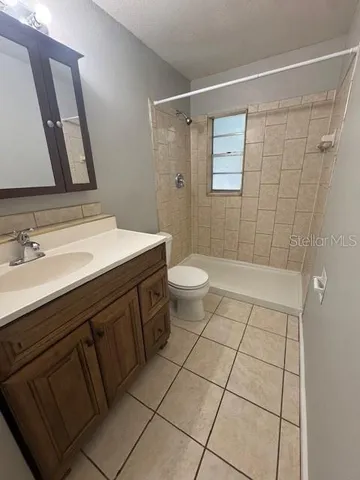 a bathroom with a sink a toilet a mirror and shower