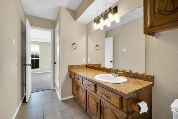 a bathroom with a granite countertop sink a mirror and a shower