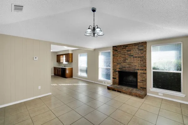 an empty room with windows and fireplace