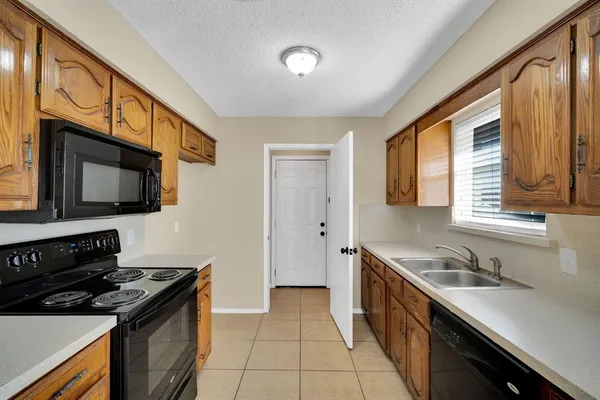 a kitchen with stainless steel appliances a stove microwave and sink