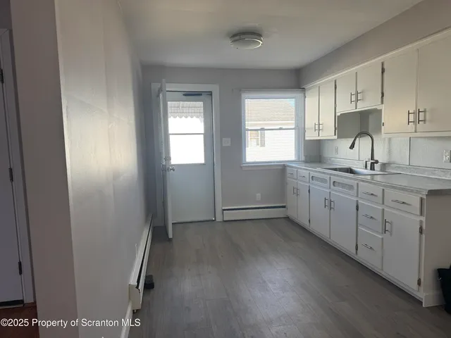 a kitchen with sink cabinets and wooden floor