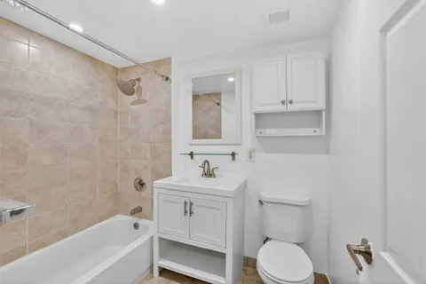 a bathroom with a sink toilet vanity and bathtub