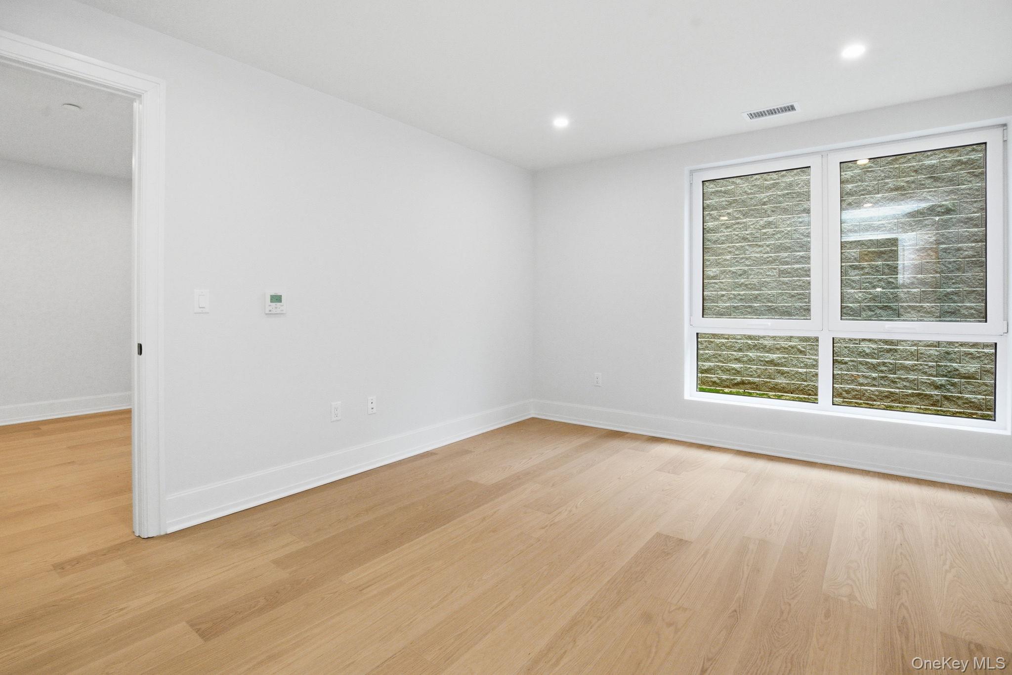 25 South Riverside Avenue, Unit 107 Croton-on-Hudson, NY 10520 - Photo 14 of 42 a view of an empty room with wooden floor and a window