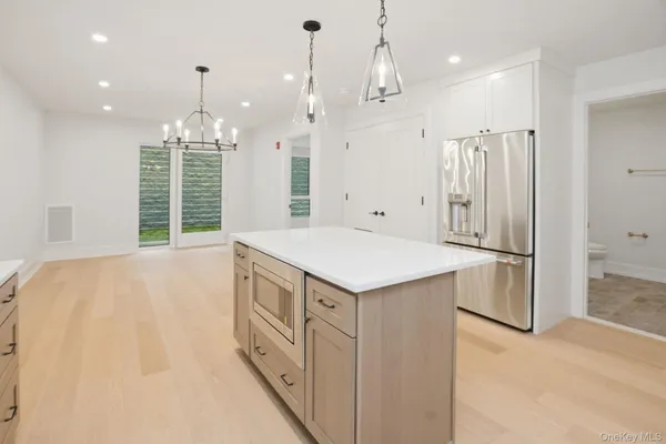 a kitchen with kitchen island a refrigerator a sink and a stove