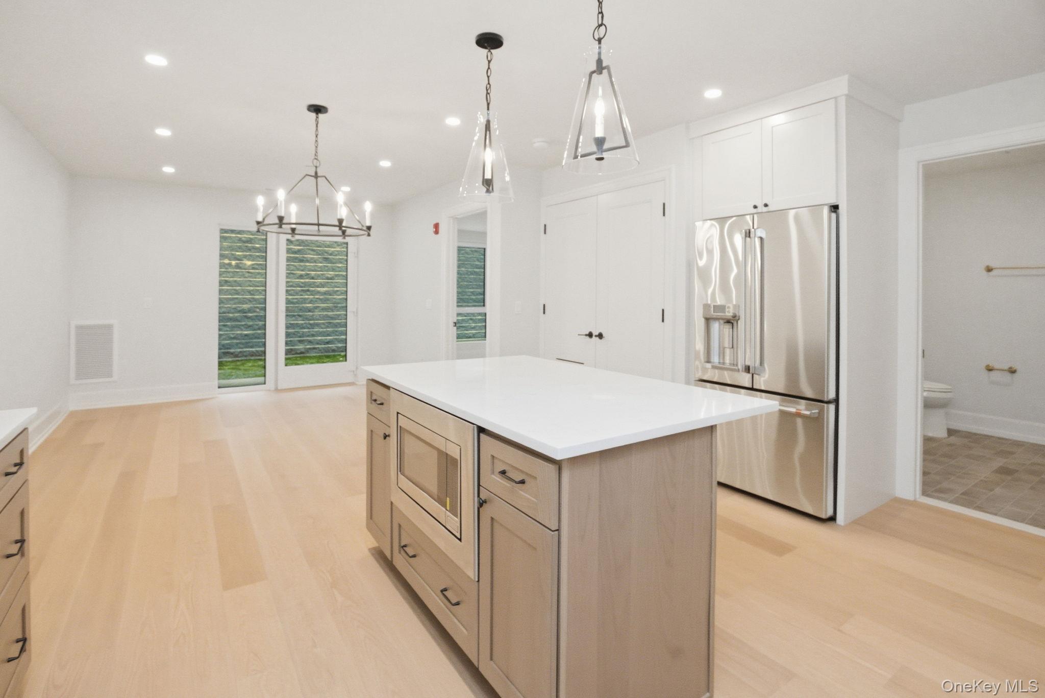 25 South Riverside Avenue, Unit 107 Croton-on-Hudson, NY 10520 - Photo 2 of 42 a kitchen with kitchen island a refrigerator a sink and a stove