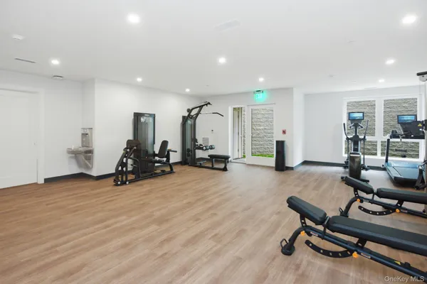 a view of a room with gym equipment and wooden floor