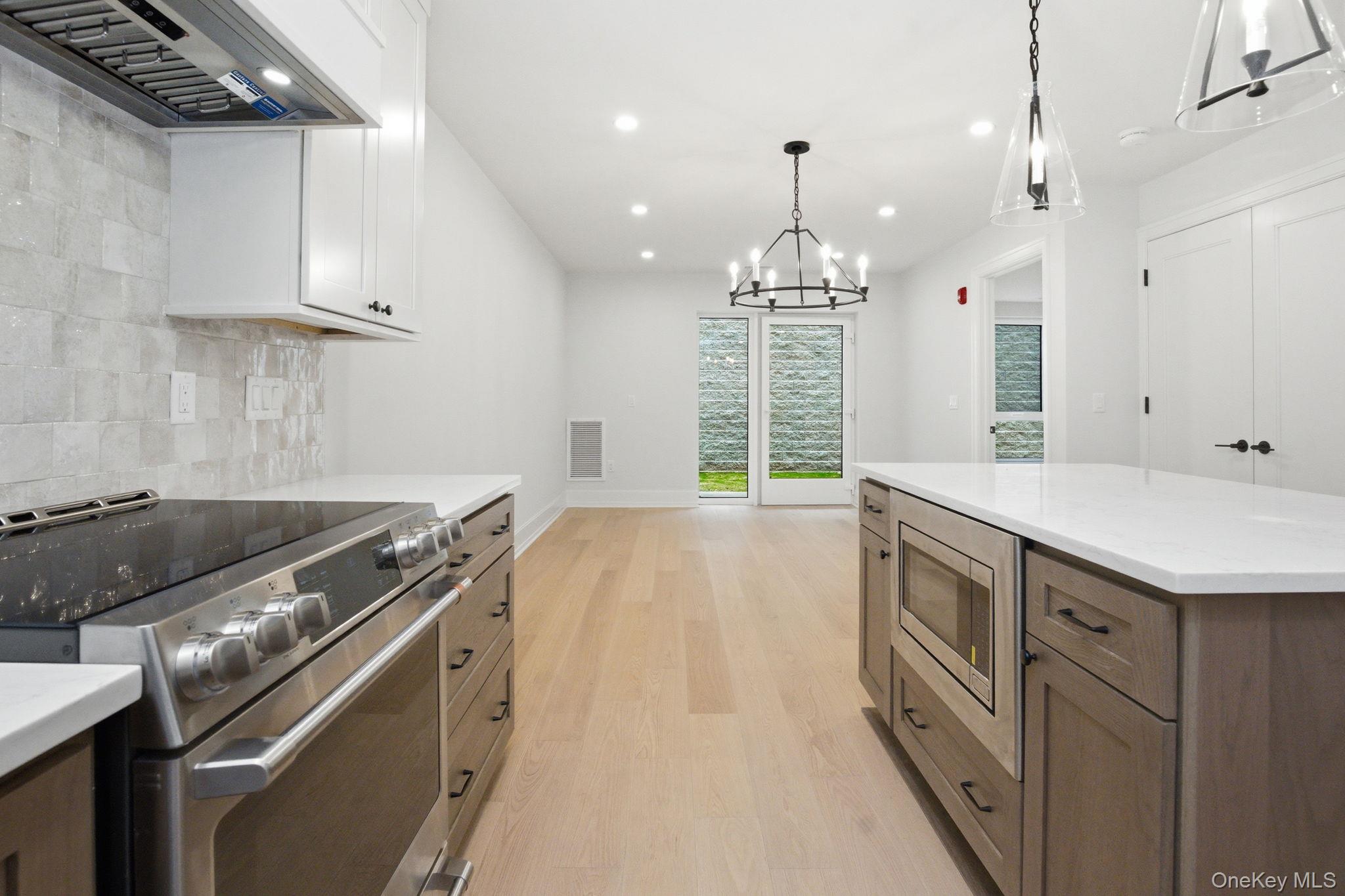 25 South Riverside Avenue, Unit 107 Croton-on-Hudson, NY 10520 - Photo 4 of 42 a kitchen with granite countertop a stove and a wooden floors