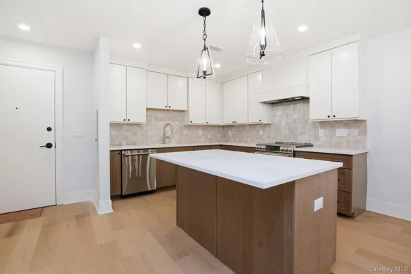 a kitchen with kitchen island a sink stainless steel appliances and cabinets
