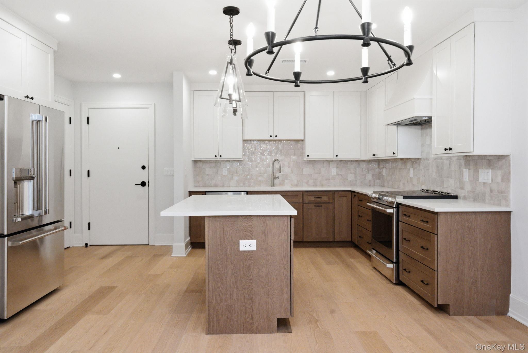 25 South Riverside Avenue, Unit 107 Croton-on-Hudson, NY 10520 - Photo 7 of 42 a kitchen with stainless steel appliances a stove a sink and white cabinets with wooden floor