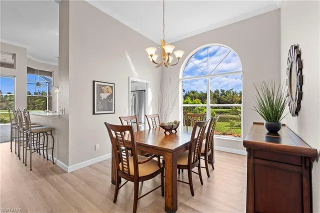 a dining room with furniture a chandelier and wooden floor