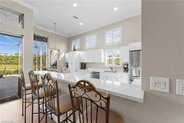 a dining room with furniture a large window and kitchen view