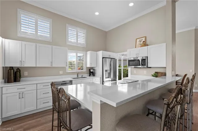 a kitchen with a table chairs and white cabinets