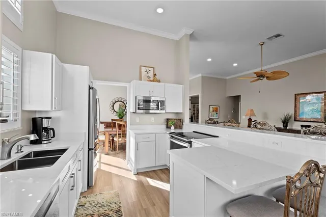 a kitchen with stainless steel appliances kitchen island granite countertop a sink and a refrigerator