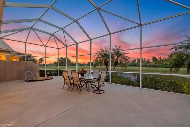 a view of a patio with a table and chairs under an umbrella