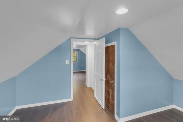 a view of hallway with closet and wooden floor