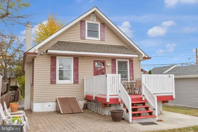 a view of a house with a barbeque and wooden stairs