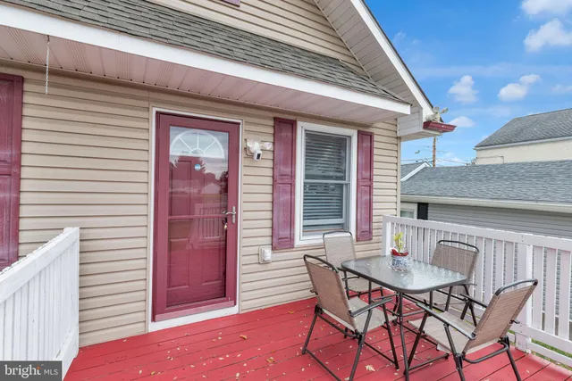a patio with table and chairs and potted plants