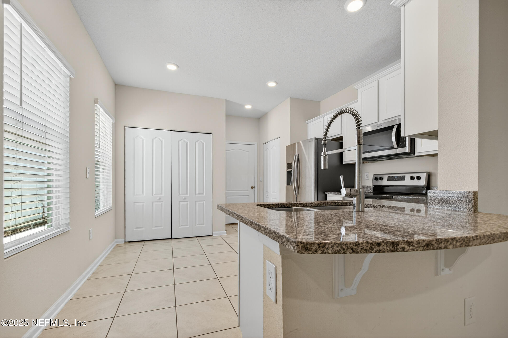 85 Talulla Trail St. Augustine, FL 32095 - Photo 17 of 56 a kitchen with stainless steel appliances granite countertop a sink stove and cabinets