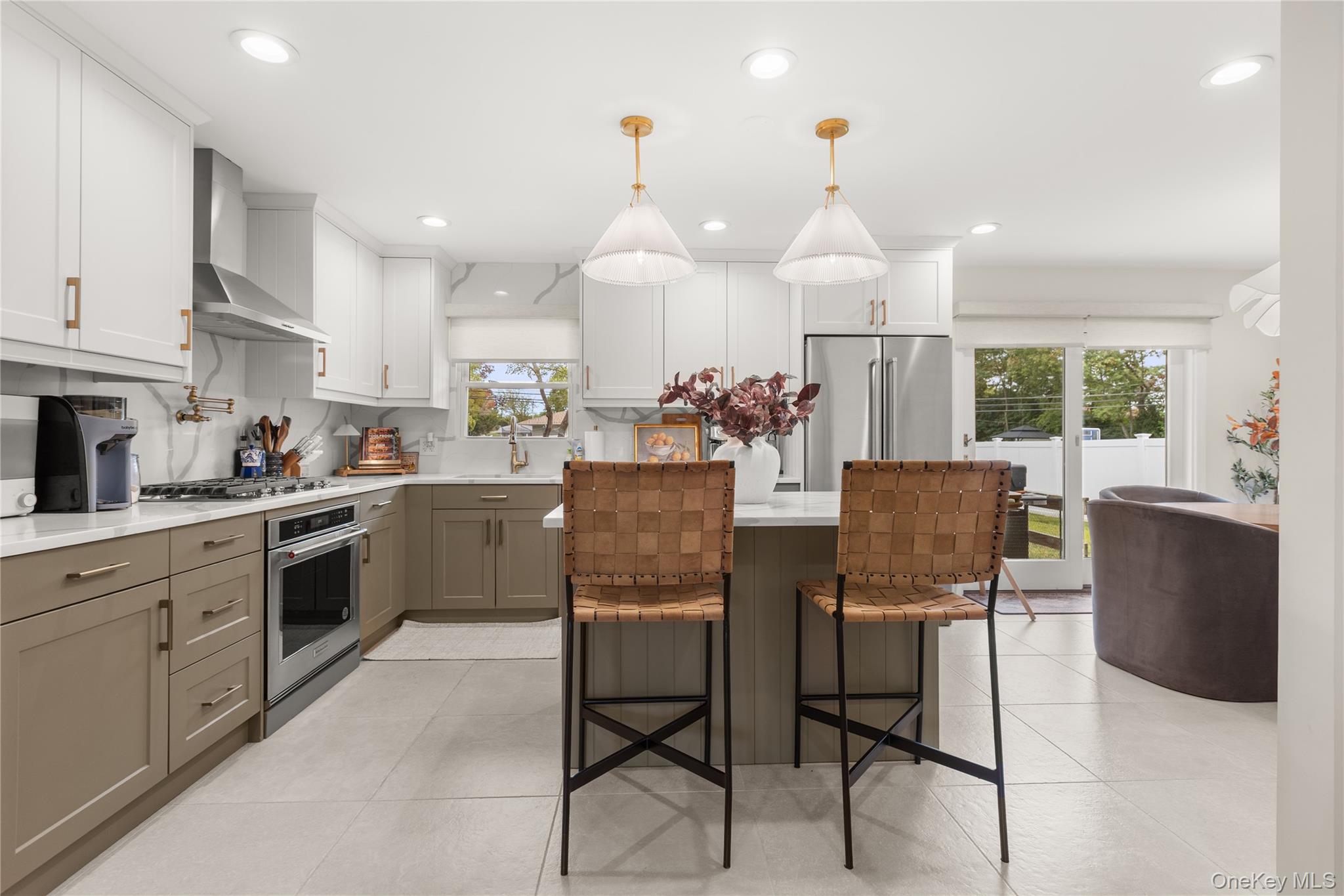 205 Timber Point Road East Islip, NY 11730 - Photo 4 of 16 Kitchen with white cabinetry, pendant lighting, wall chimney range hood, light tile patterned floors, and appliances with stainless steel finishes
