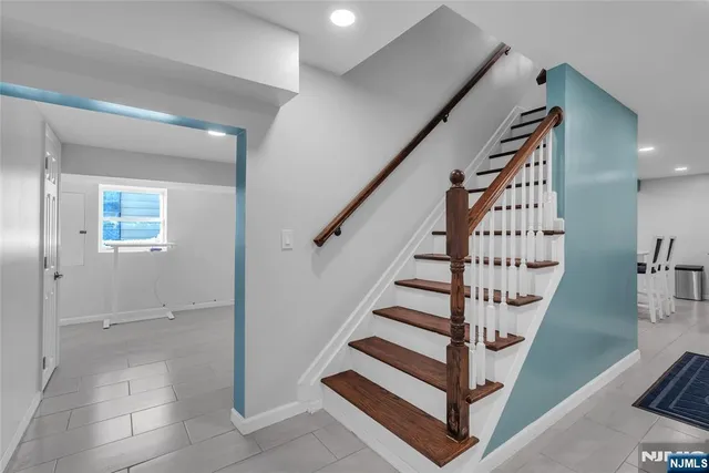 a front view of a house with a large tree