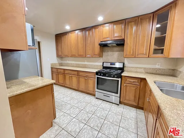 a kitchen with stainless steel appliances granite countertop a refrigerator and a sink