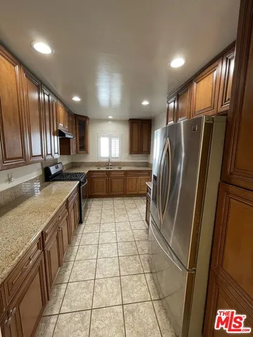 a kitchen with stainless steel appliances a sink a stove a microwave and cabinets